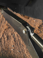 Close-up of heavy-duty Lewis Built Performance Ford Super Duty radius arms connected with Grade 8 bolts and rod ends, set against reddish-brown dirt.